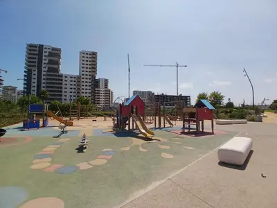 a park with a playground with a slide at Duplex Luxe 3 Chambres Vue Mer & Piscine à Zenata Eco City in Aïn Harrouda