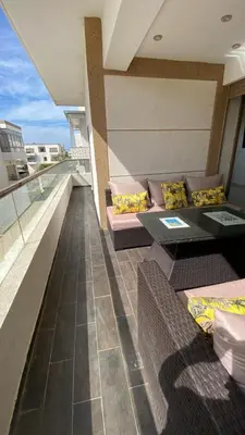 a balcony with couches and tables on a building at Puerto Banus Appartement A4 in Mohammedia