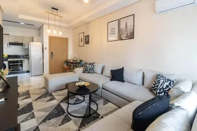 a living room with a couch and a table at Studio chic et paisible avec piscine parc et plage in Aïn Harrouda