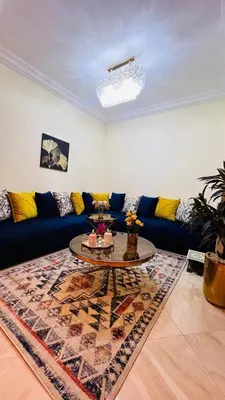 a living room with a blue couch and a table at CASABAY KETTANI SIDI Rahal in Sidi Rahal