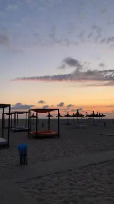 a beach with a group of umbrellas on the beach at CASABAY KETTANI SIDI Rahal in Sidi Rahal