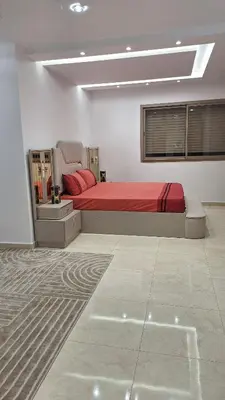 a bedroom with a large bed with red sheets at Étage d'une prestigieuse villa in Rabat