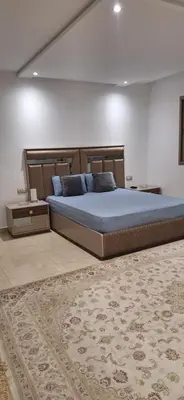 a large bed in a bedroom with a rug at Étage d'une prestigieuse villa in Rabat