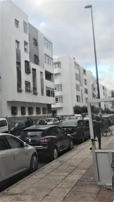 a parking lot with cars parked in front of buildings at Charmant appartement pour votre séjour a Bouskoura a Casablanca in Bouskoura