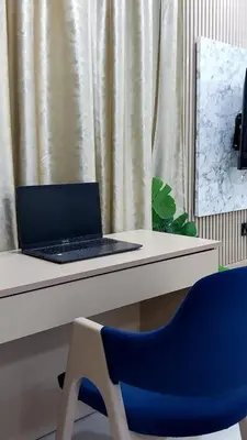 a laptop computer sitting on a desk with a blue chair at Studio Chefchaoun in Deroua