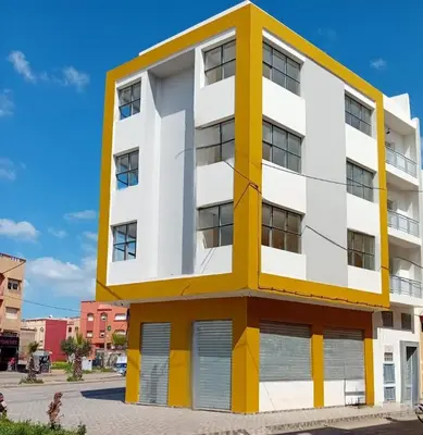 a white and yellow building on a street at Studio Chefchaoun in Deroua