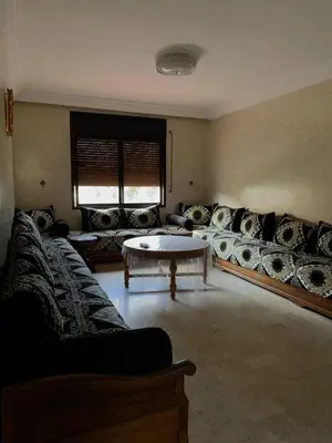 a living room with a couch and a table at RESIDENCE PLAGE MANESMANe in Mohammedia