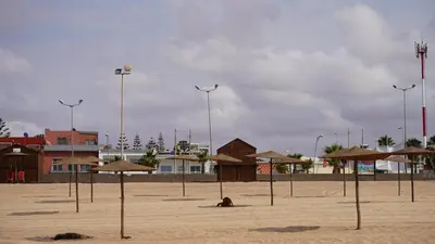 a sandy beach with umbrellas and buildings on it at Cosy Studio Sea View in Casablanca in Tamaris