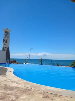 a large blue swimming pool next to a lighthouse at Cosy Studio Sea View in Casablanca in Tamaris
