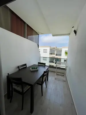 a dining room with a table and chairs on a balcony at Appartement Blanca Beach lumineux avec balcon in Sidi Rahal