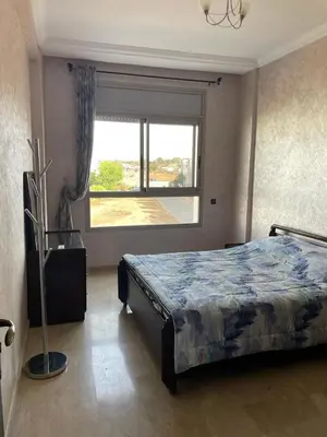 a bedroom with a bed and a large window at Skhirat Beach Appartement in Skhirat