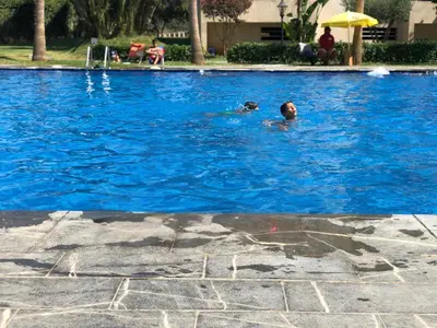 a man swimming in a swimming pool at 2 Bedroom Apartment in Mohammedia