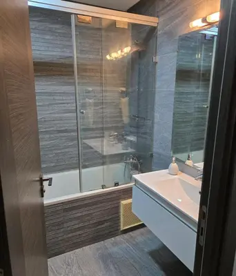 a bathroom with a shower and a tub and a sink at 2 Bedroom Apartment in Mohammedia