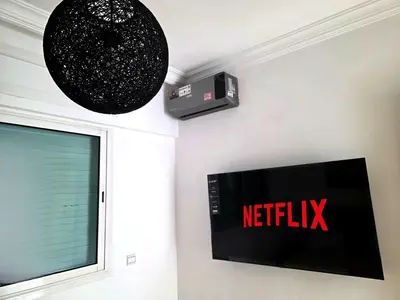 a television on a wall with a netflix sign on it at Seaside Artist's Villa in Temara