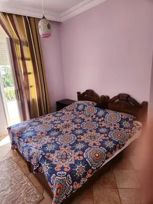 a bed with a quilt on it in a bedroom at Villa mouna in Mohammedia