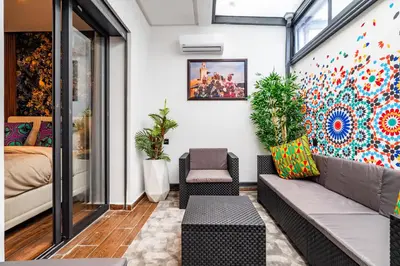 a living room with a couch and a painting on the wall at Résidence Cerezo in Maarif