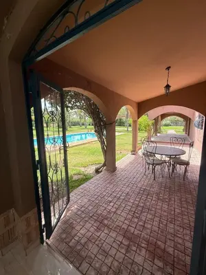 a patio with a table and chairs and a pool at Chic home with a private pool in Dar Mouddene