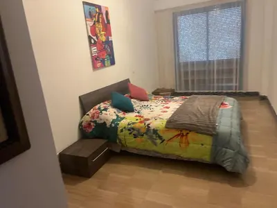 a bedroom with a bed with a colorful comforter and a window at Ocean Symphony in Îlot de Skhirat