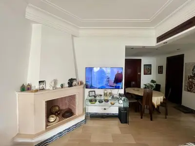 a living room with a fireplace and a dining table at Ocean Symphony in Îlot de Skhirat
