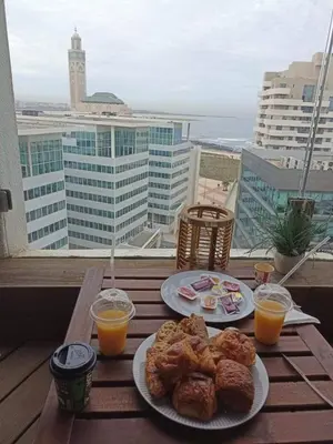 a table with two plates of food and two glasses of orange juice at Stylish Apartment with a seaview 9 in Casablanca