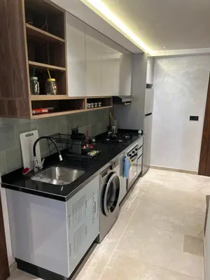 a kitchen with a sink and a washing machine at Studio au Parc Mohammedia in Mohammedia