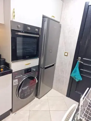 a kitchen with a washing machine and a microwave at Votre Appartement neuf meublé vous attend in Skhirat