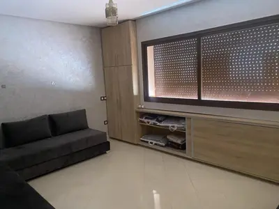 a living room with a couch and a flat screen tv at Villa pied dans l'eau in Sidi Rahal
