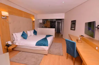 a bedroom with a large white bed with blue pillows at Le 135 appart hotel in Casablanca
