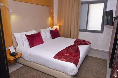 a hotel room with a large bed with red pillows at Le 135 appart hotel in Casablanca