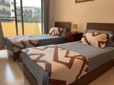 a bedroom with two beds and a window at Cosy apartment in Bouznika in Bouznika