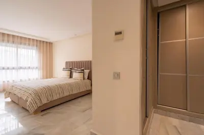 a bedroom with a bed and a large window at Le yacht palace beachfront residence 2 BR 2 BA in Casablanca