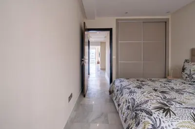 a bedroom with a bed and a door to a hallway at Le yacht palace beachfront residence 2 BR 2 BA in Casablanca