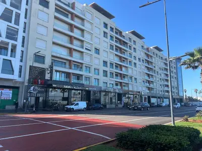 a large building on a street with a parking lot at Le yacht palace beachfront residence 2 BR 2 BA in Casablanca