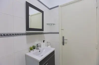 a white bathroom with a sink and a mirror at 2BR Apartment in Prestigious Mahaj Riad by MERAT HOME in Rabat