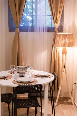 a white table with chairs and a table with a lamp at 2BR Apartment in Prestigious Mahaj Riad by MERAT HOME in Rabat