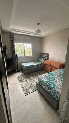 a bedroom with two beds and a couch and a window at Rayan beach Residence avec picine a tamaris in Tamaris