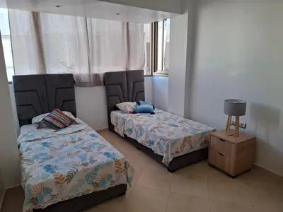 a bedroom with two beds and a night stand at Apt 3 ch Casablanca 3 min Casa Voyageurs idéal pour une famille in Casablanca