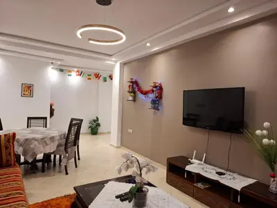 a living room with a table and a flat screen tv at Apt 3 ch Casablanca 3 min Casa Voyageurs idéal pour une famille in Casablanca