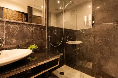a bathroom with a sink and a glass shower at Le yacht luxury apartment 2BR 2BA corniche with parking in Casablanca