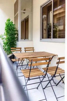 a group of wooden tables and chairs on a patio at Luxury 2 BR 2 BA Alsace Lorraine downtown in Casablanca