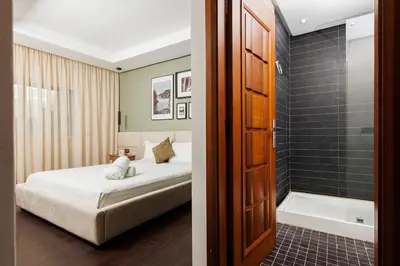 a bedroom with a bed and a shower and a tub at 3BR Modern Stay in Heart of Rabat in Rabat