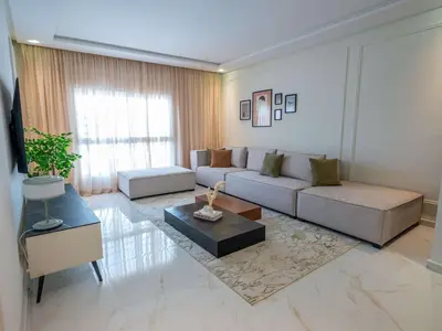 a living room with a couch and a table at Modern & Central 2BR Stay in Rabat in Rabat