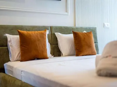 a bed with four pillows on it in a room at Modern & Central 2BR Stay in Rabat in Rabat