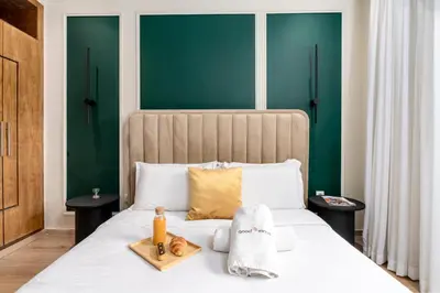a bedroom with a white bed with green walls at The Loft Residence by GoodMove - Maarif Casablanca in Casablanca
