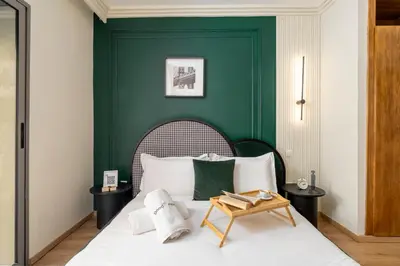 a bedroom with a bed with a green wall at The Loft Residence by GoodMove - Maarif Casablanca in Casablanca