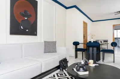 a living room with a white couch and a painting at The Loft Residence by GoodMove - Maarif Casablanca in Casablanca