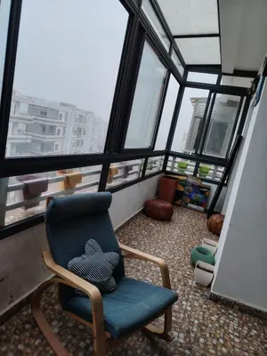 a chair sitting in a room with windows at Le mataki in Mohammedia