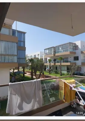 a balcony with a clothes line and a building at Blue beach in Sidi Rahal