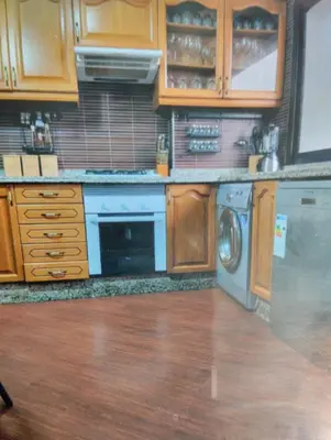 a kitchen with wooden cabinets and a washing machine at Spacious with Great Location in Casablanca