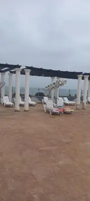a row of lounge chairs and umbrellas on a beach at Vue Mer & Sérénité, Appartement Chic avec Piscine à Dar Bouazza in Tamaris